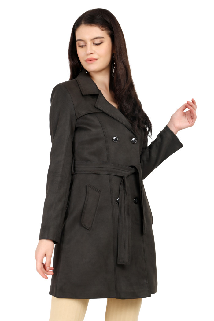 A woman is holding a standing side pose, wearing Coatsnmore’s olive double-breasted trench coat with a lapel collar, button closure, belt, side pockets, and skin bottoms.