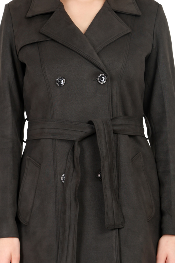 A woman in a cropped image is wearing Coatsnmore’s olive double-breast trench coat with a lapel collar, button closure, belt and side pockets.