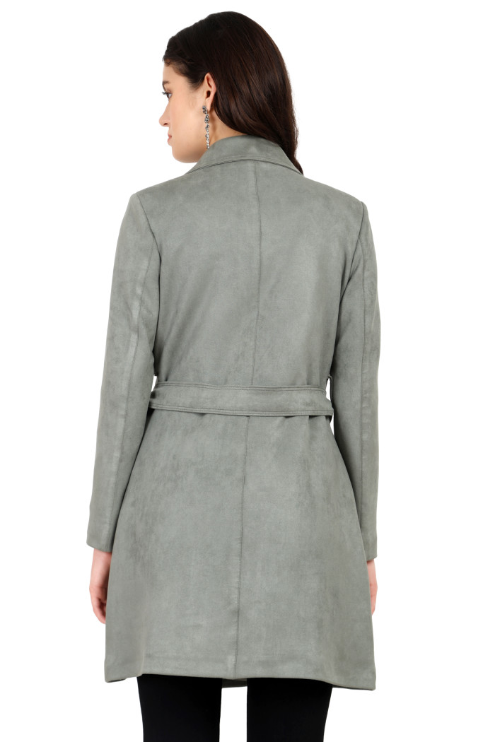 A back pose of a standing woman wearing Coatsnmore’s pista double-breasted trench coat with a belt and bottom.