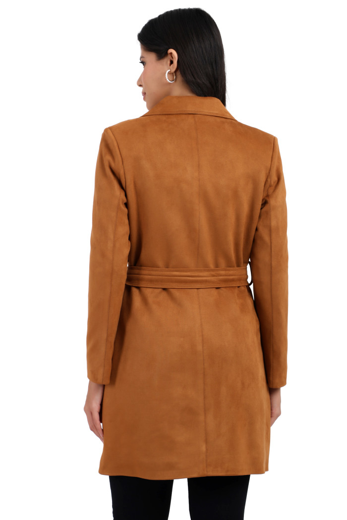 A back pose of a standing woman wearing Coatsnmore’s tan double-breast trench coat with a belt and bottom.