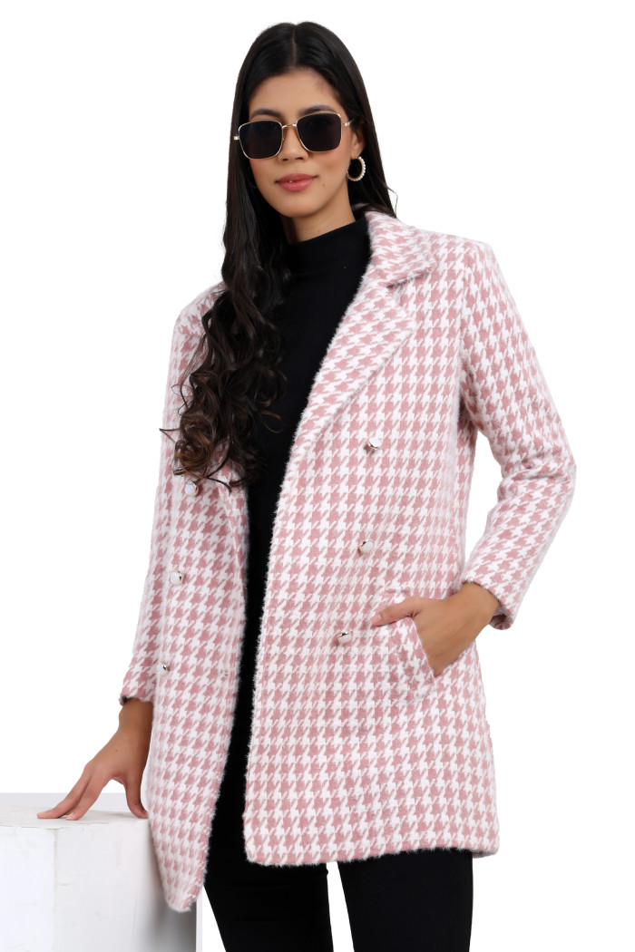 A side view of a woman highlights Coatsnmore’s pink double-breasted semi-long coat featuring a lapel collar, button-up design, side pockets styled in black jeans with her right hand in the pocket.