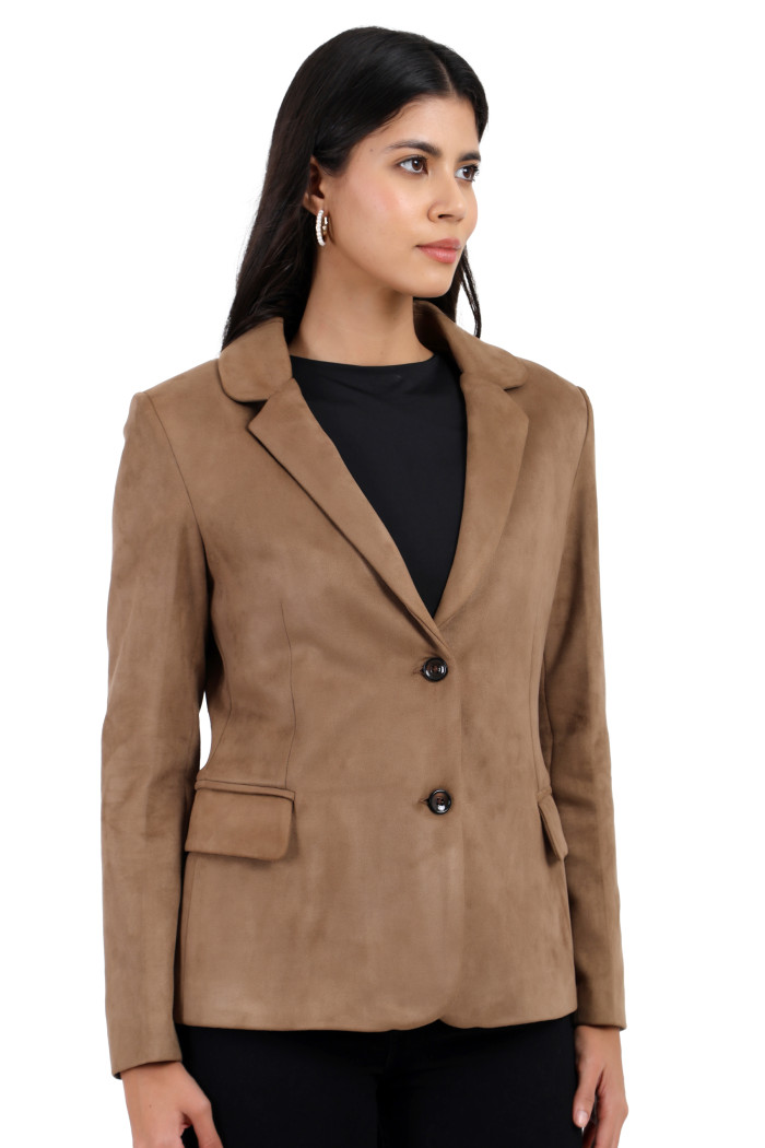 A woman is giving a standing side pose wearing Trufit’s short-length coat in olive with a lapel collar, side pockets, and a button closure in one piece while holding the collar with her left hand.