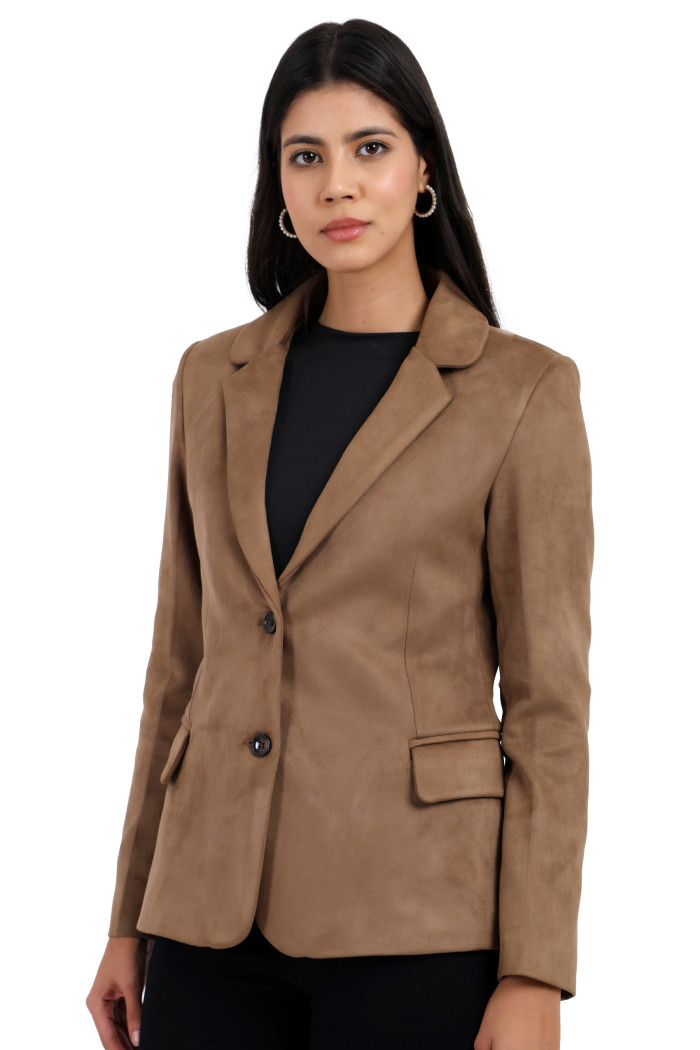 A woman is giving a standing side pose wearing Trufit’s short-length coat in olive with a lapel collar, side pockets, and a button closure in one piece while holding her hands.