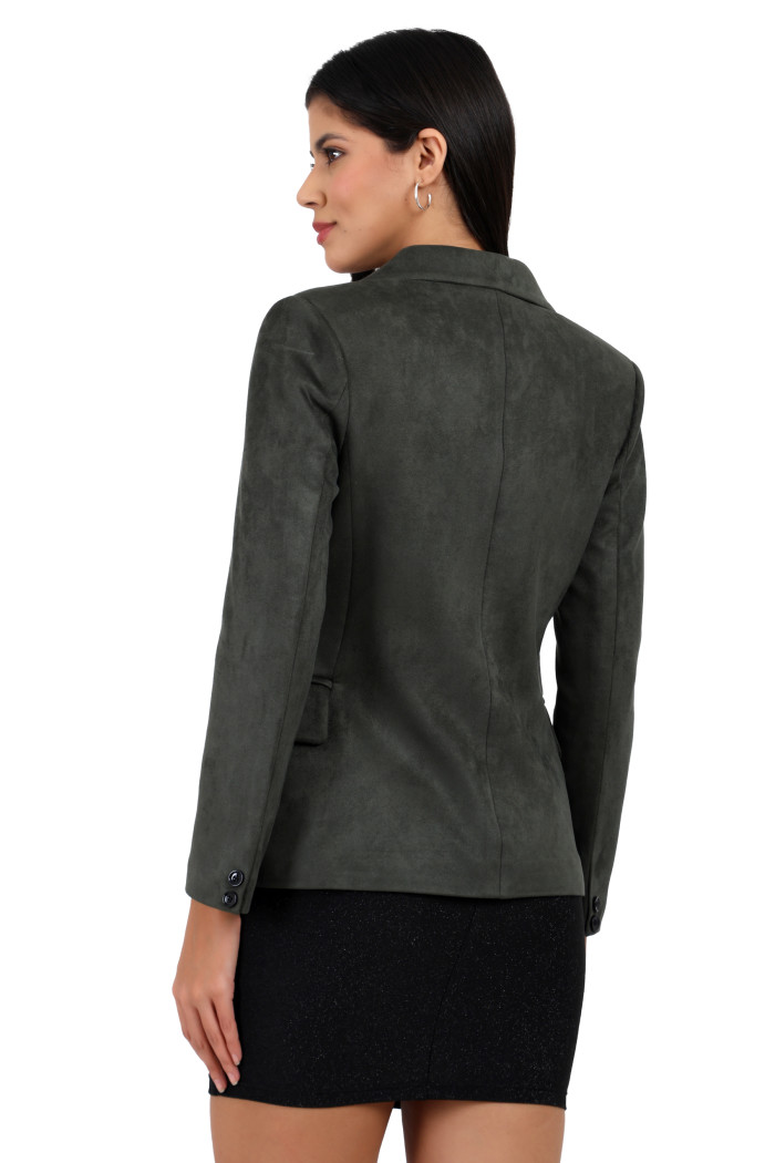 A back pose of a standing woman wearing Trufit’s short-length coat in olive with a lapel collar and one piece.