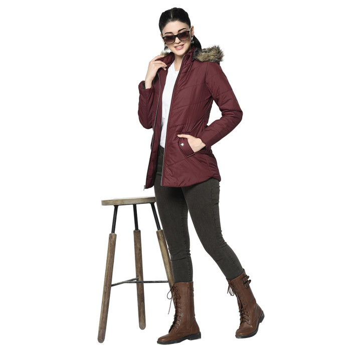 A woman wearing a Maroon Puffer jacket with a high neck, hood, zipper closure and pocket in hand designed for casual winter layering and comfort.