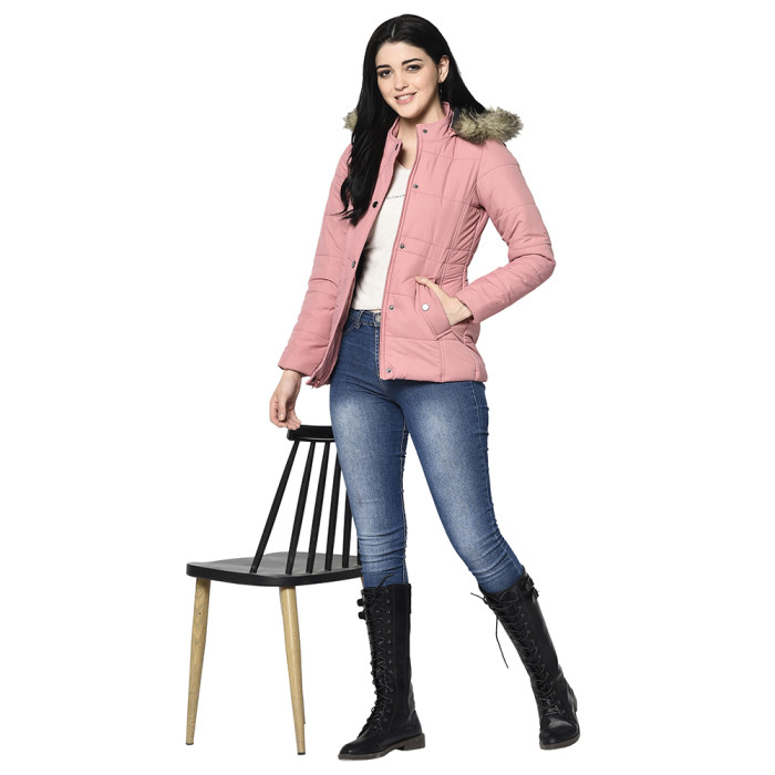 A woman wearing a Light Pink Puffer jacket with a high neck, hood, zipper closure and pocket in hand designed for casual winter layering and comfort.